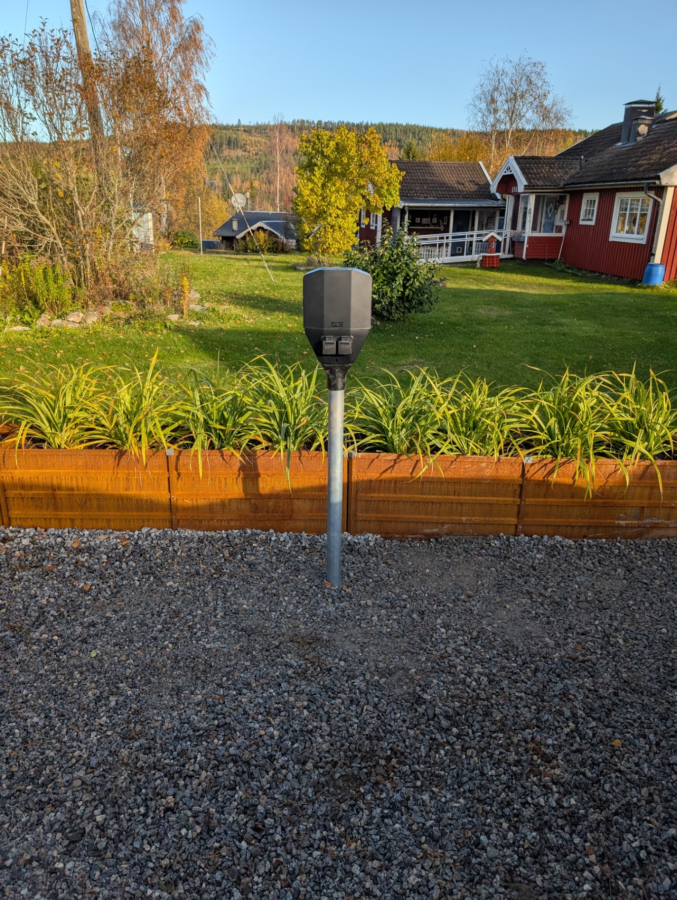 Utomhusstolpe med uttag i trädgård